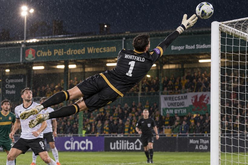 Goalkeeper Cai Whitfield flies across goal to make a save